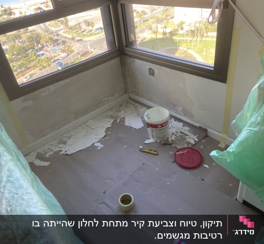 חדר בשיפוץ עם קירות מתקלפים, דלי צבע וכלי עבודה